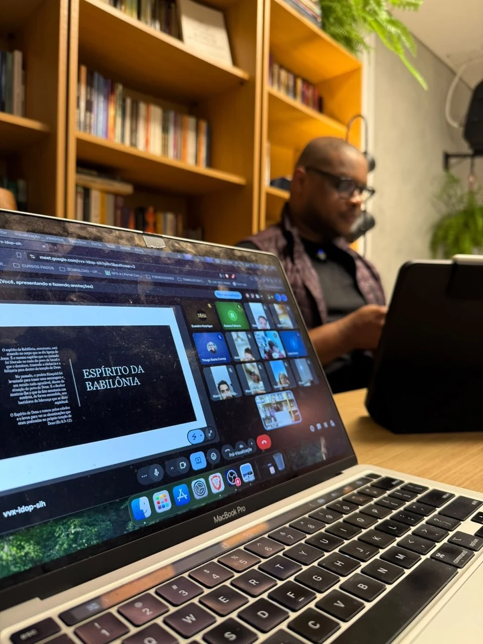 Aula online da Mikra, com participantes por videoconferência e professor na biblioteca